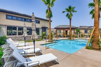 Our apartments have a swimming pool with chairs and palm trees